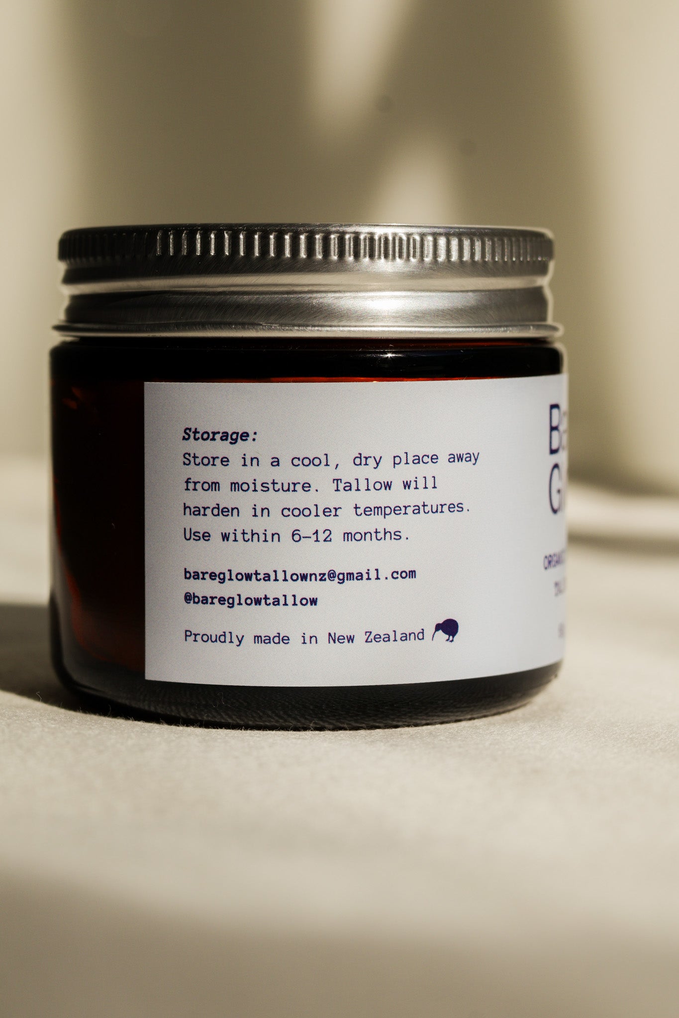 Jar of Bare Glow Tallow Balm with the storage instructions