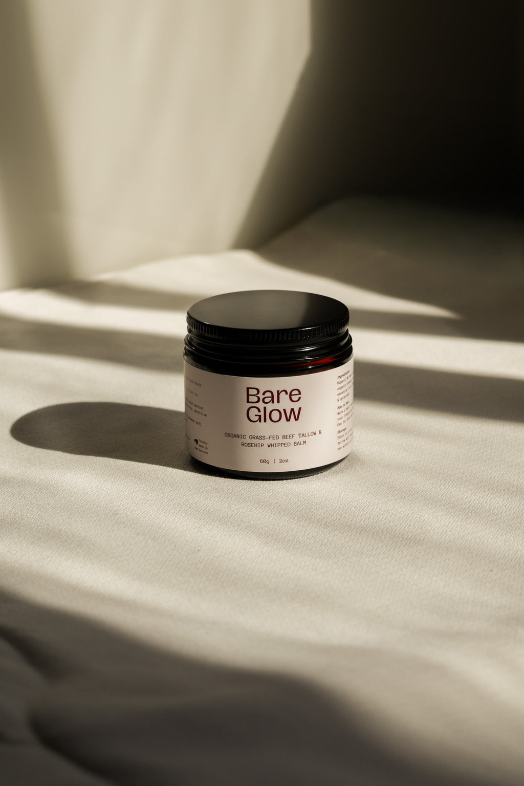 Bare Glow Organic Rosehip Tallow balm on a beige background