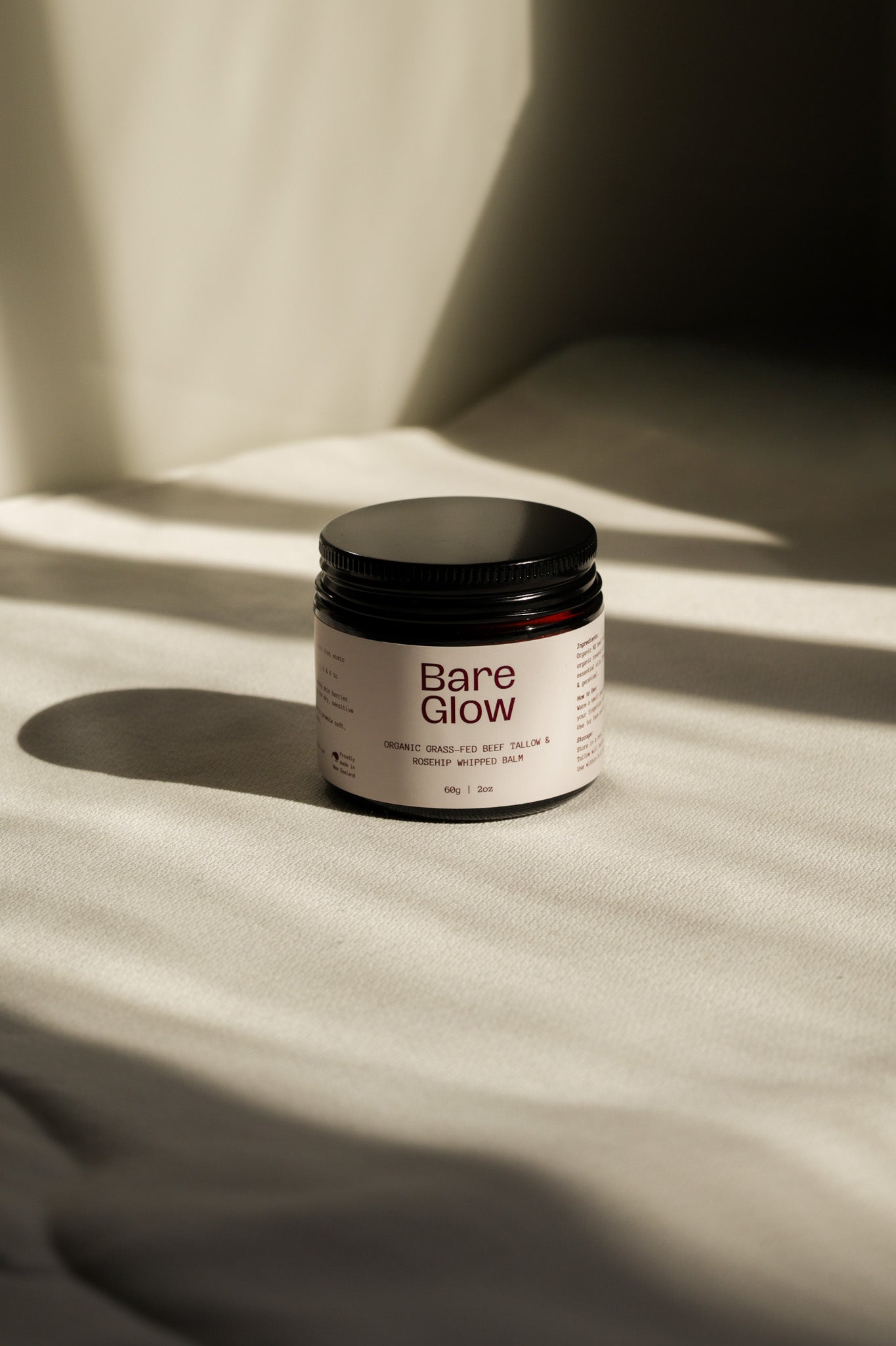 Bare Glow Organic Rosehip Tallow balm on a beige background