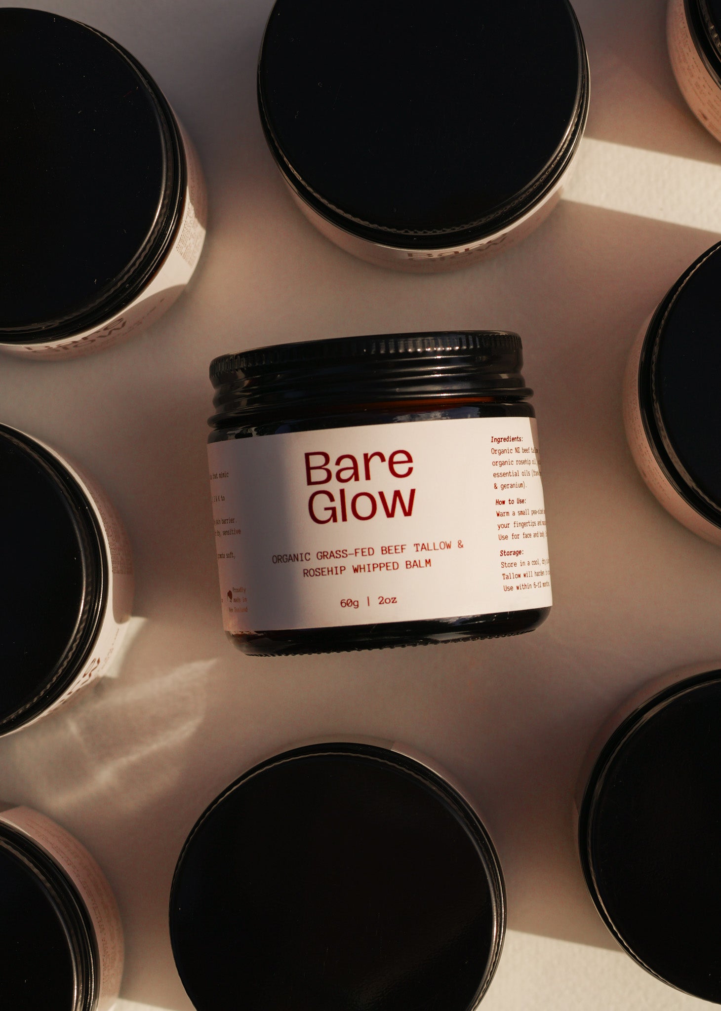Multiple jars of Bare Glow Rosehip Tallow Balm with one jar in focus 
